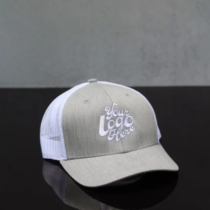 Front view of a custom embroidered grey and white trucker hat with mesh back and logo placeholder