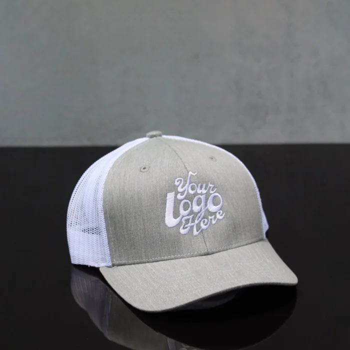 Front view of a custom embroidered grey and white trucker hat with mesh back and logo placeholder
